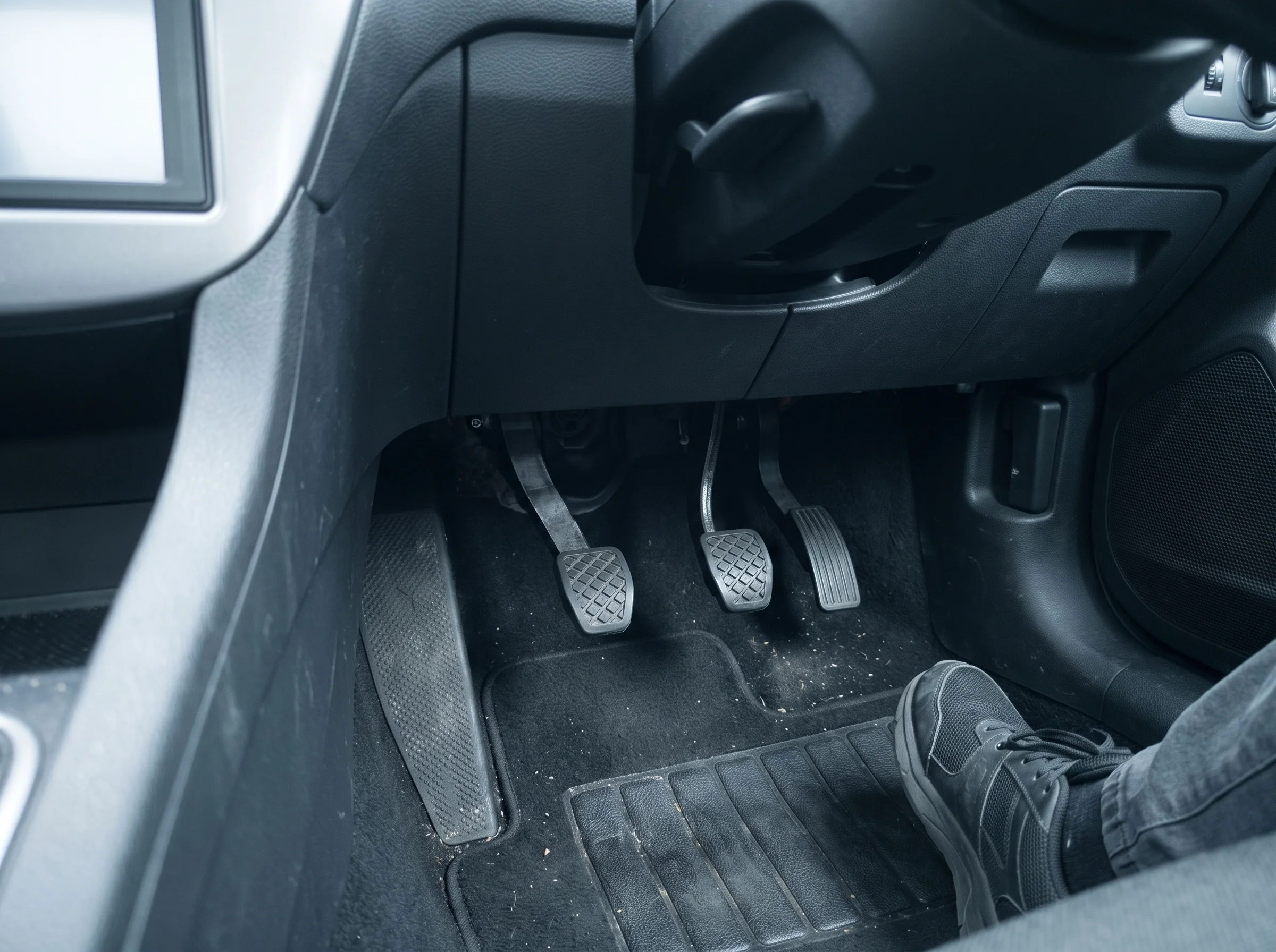 Dual-control brake and clutch pedals fitted in the passenger footwell of a manual learner car
